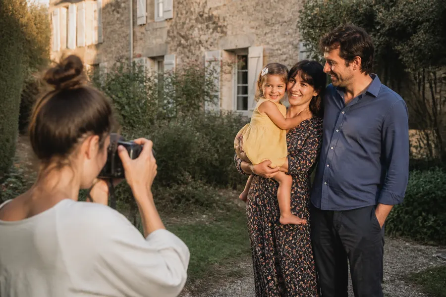 Un photographe capture un portrait de famille dans le jardin